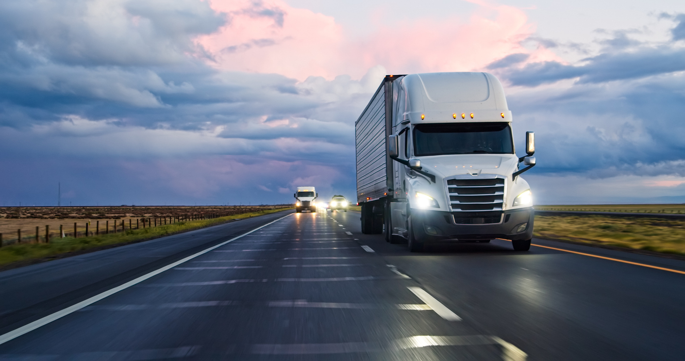 Expedited shipping truck driving on highway at sunrise to meet urgent delivery deadlines.